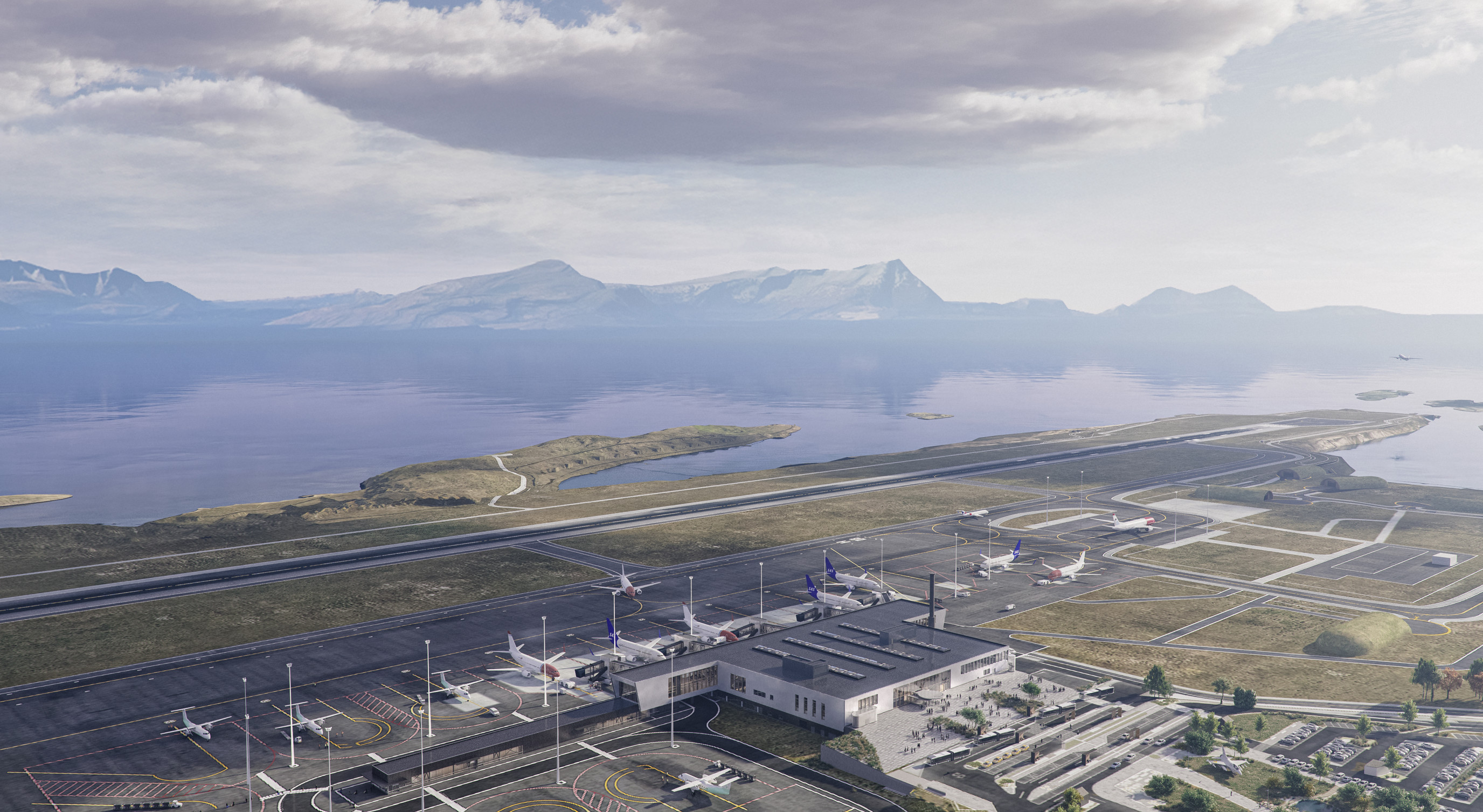 Luftfoto av en kystflyplass med fly på rullebanen, omgitt av parkeringsplasser og veier, satt mot en bakgrunn av fjell og en vannmasse under en skyet himmel