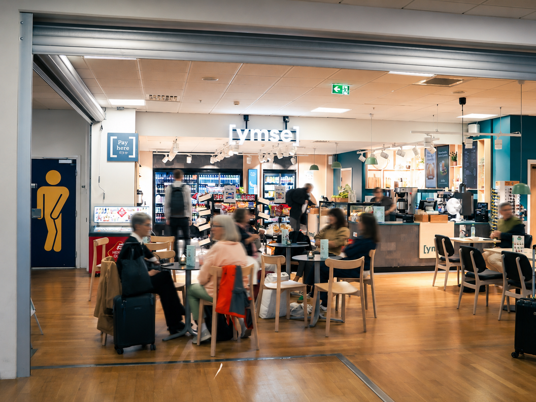 Assorterte smørbrød med salat, ost og kjøtt i en bakeridisk, med korn-toppede boller med synlige prislapper i norske kroner