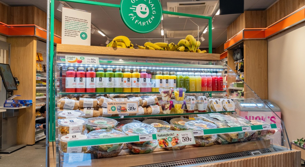 Moderne WHSmith-kiosk på en flyplass som tilbyr dagligvarer, snacks og drikkevarer under livlig belysning
