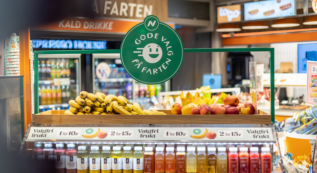 Moderne WHSmith-kiosk på en flyplass som tilbyr dagligvarer, snacks og drikkevarer under levende belysning