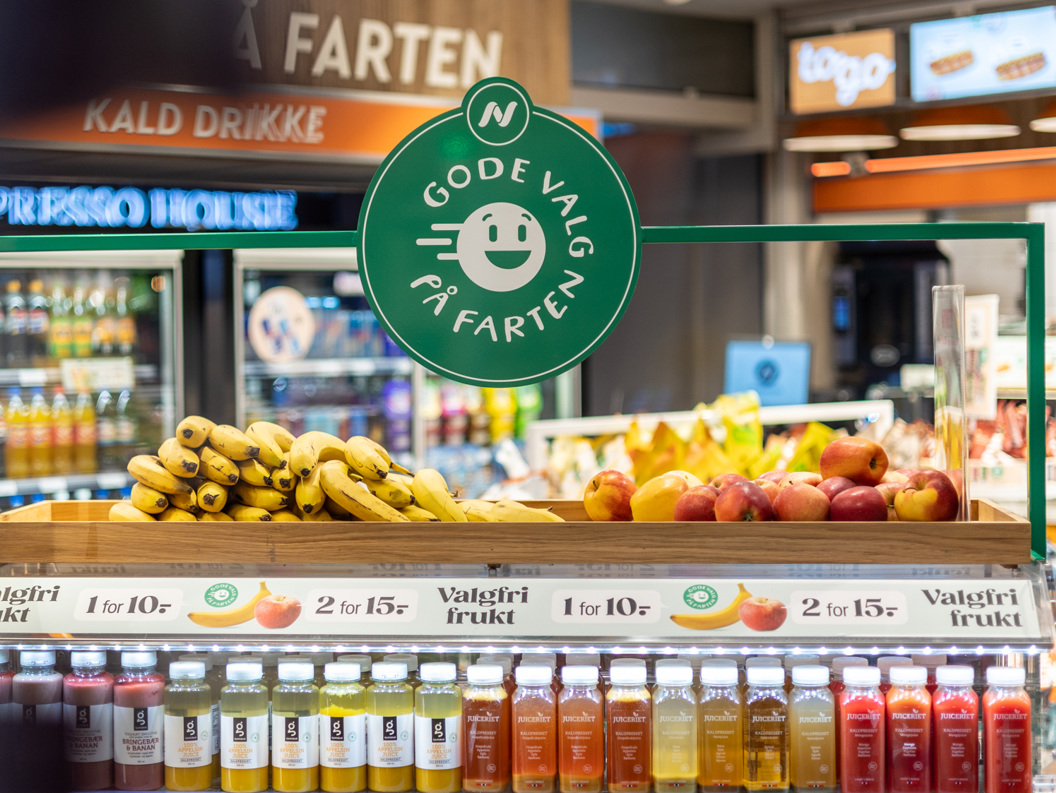 Moderne WHSmith-kiosk på en flyplass som tilbyr dagligvarer, snacks og drikkevarer under levende belysning