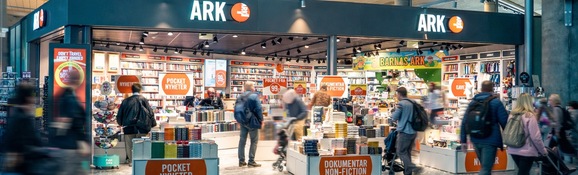 En kvinne som blar i fargerike barnebøker på en grønn bokhylle i en bokhandel, fokusert på å velge en tittel