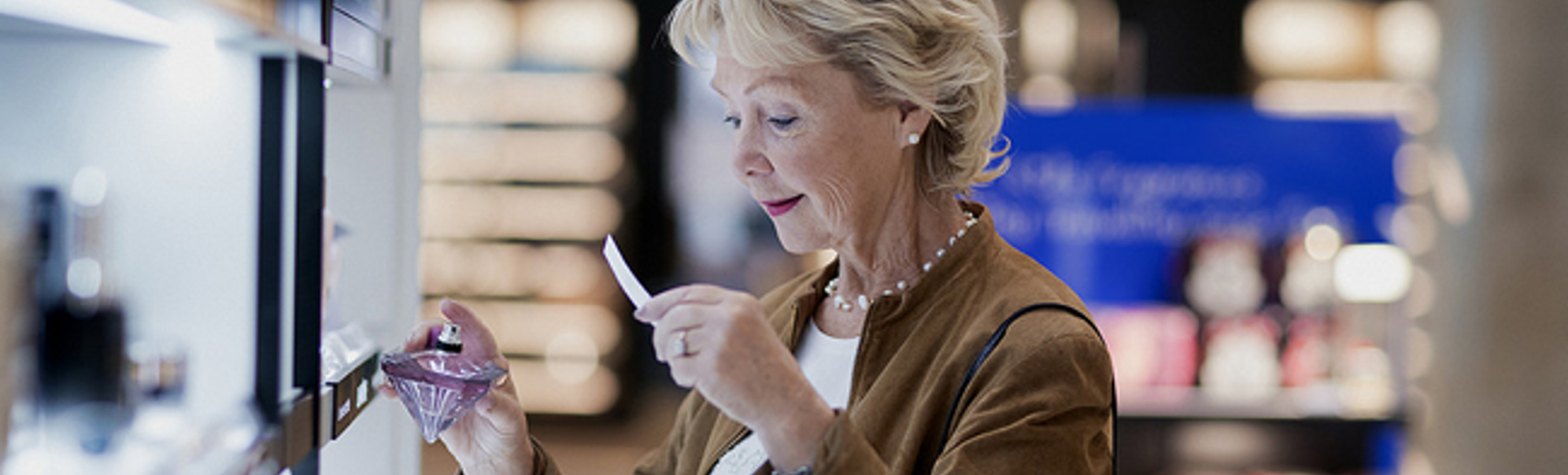 Eldre kvinne prøver parfyme på eit kjøpesenter