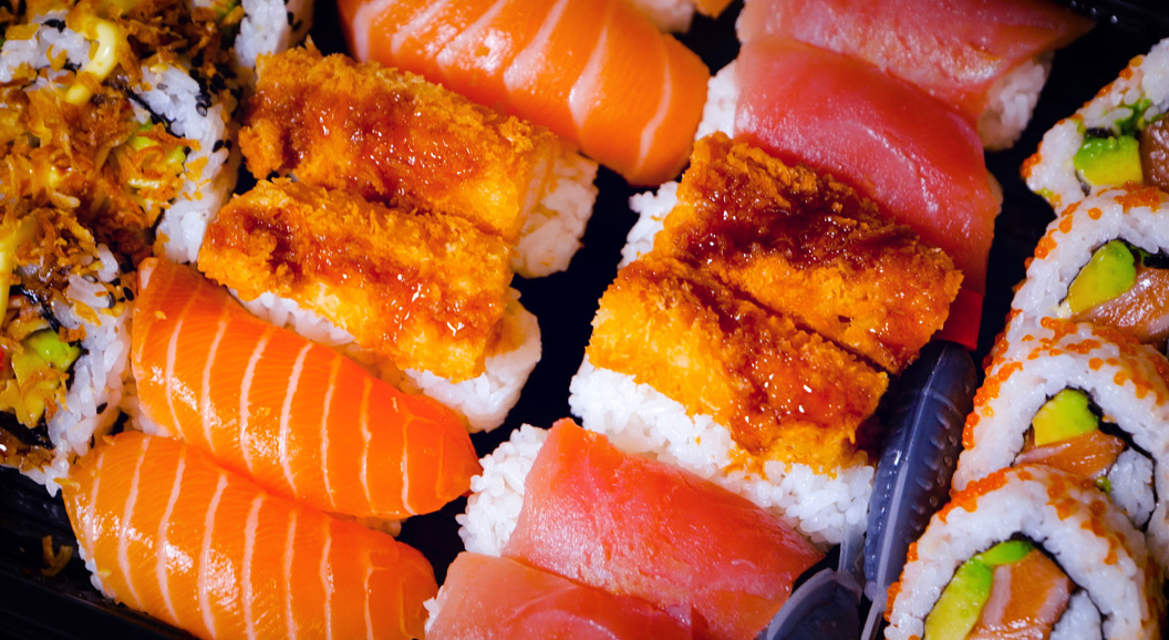 Sushi-fat med assorterte bitar av laks, tunfisk og tempura, samt rullar med avokado og fisk