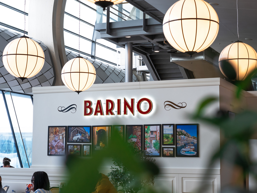 Café Barino i moderne interiør med runde lamper, veggdekorasjoner og folk som sitter ved bord