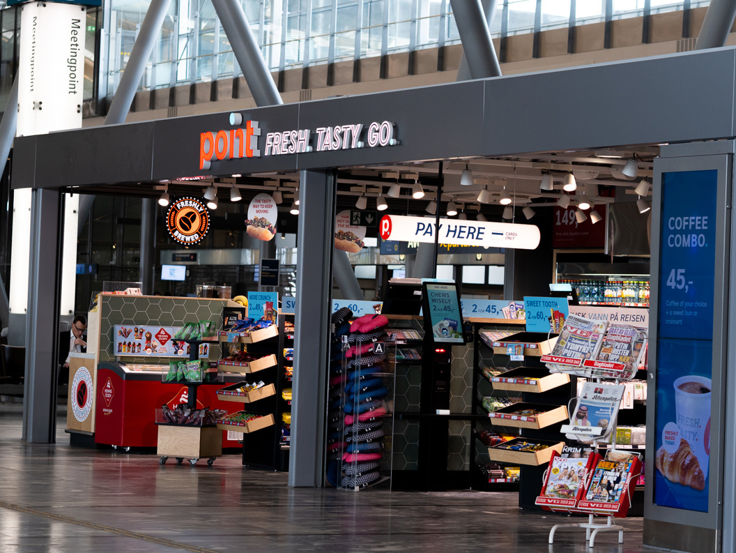 Kiosk i nærbutikk i en terminal på flyplassen med snacks, drikkevarer og magasiner utstilt