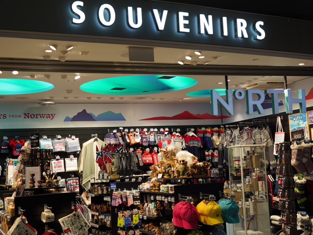 Suvenirbutikk i Norge med tradisjonelle skandinaviske klær, flagg og diverse gaver med fremtredende skilting for "Suvenirer" og "Nord