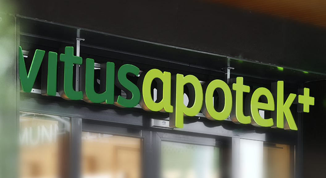 Vitusapotek skilt på bygning, grøne og kvite bokstavar i moderne design