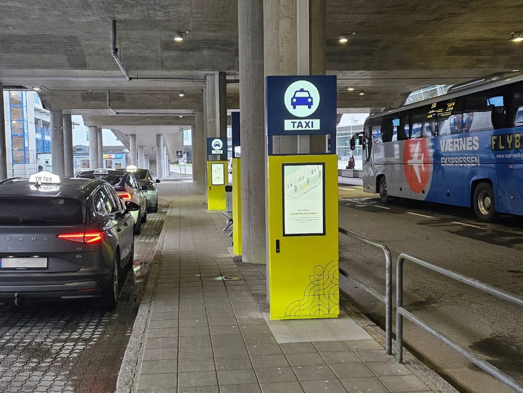 A full size Fast Travel kiosk displayed outside the terminal between taxi and bus
