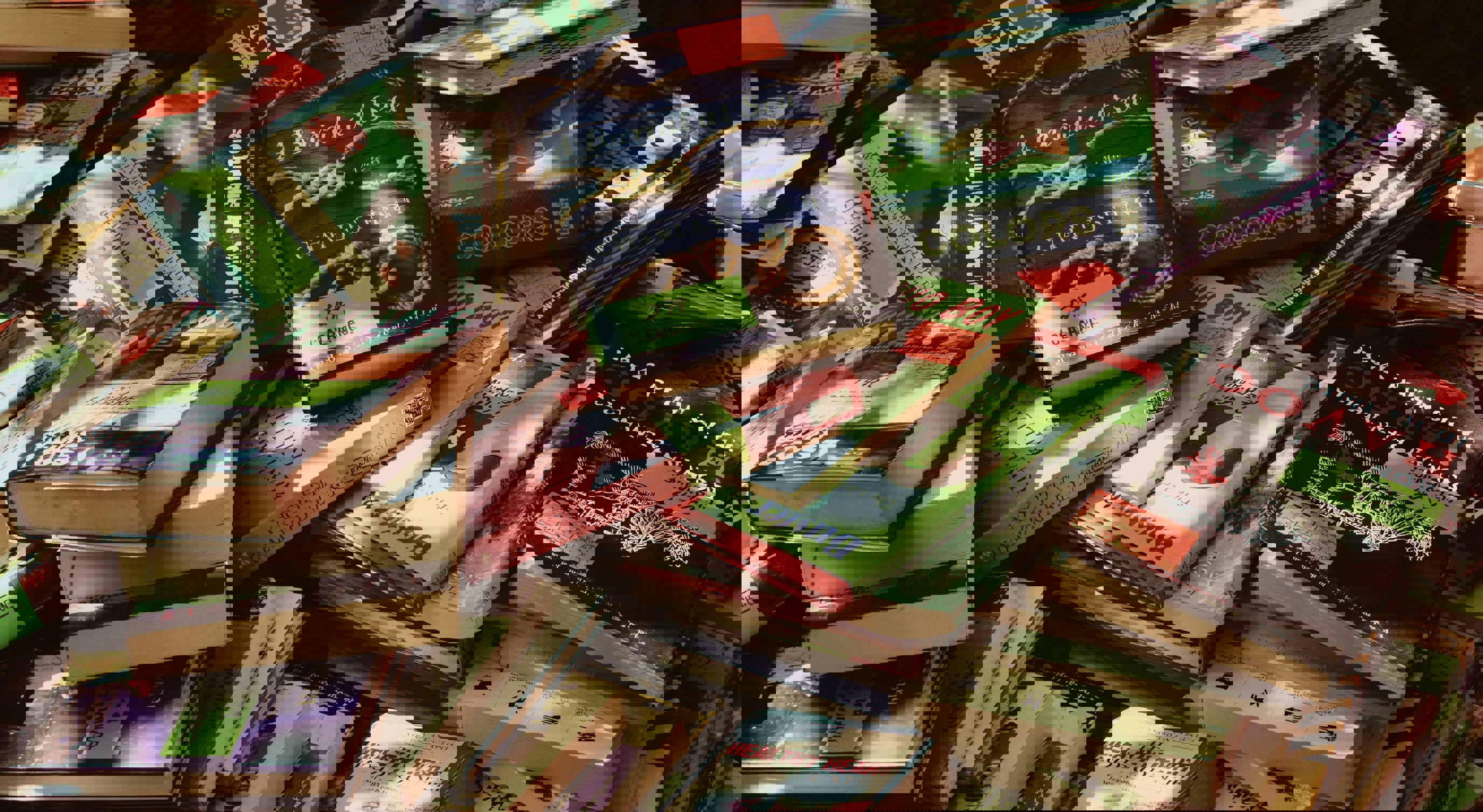 Stable med forskjellige bøker med fargerike omslag på et utforsalg, med ulike sjangre og titler