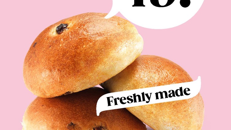 Freshly baked wheat, raisin, and chocolate buns on a pink background with a price promotion of three for 49