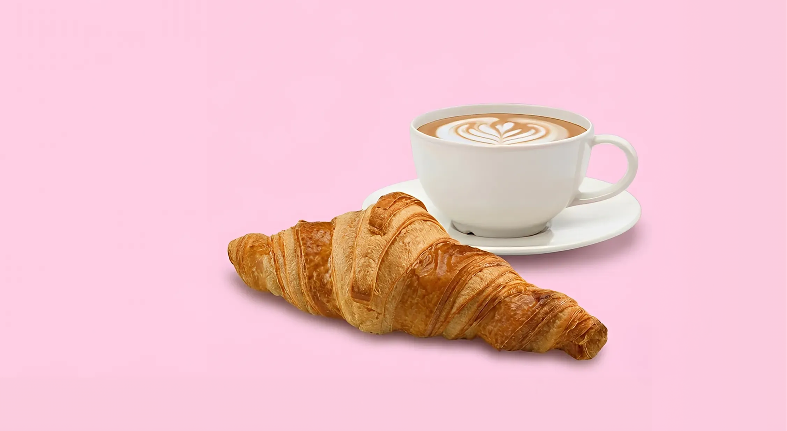 Kopp med kaffe og en croissant ved siden av.