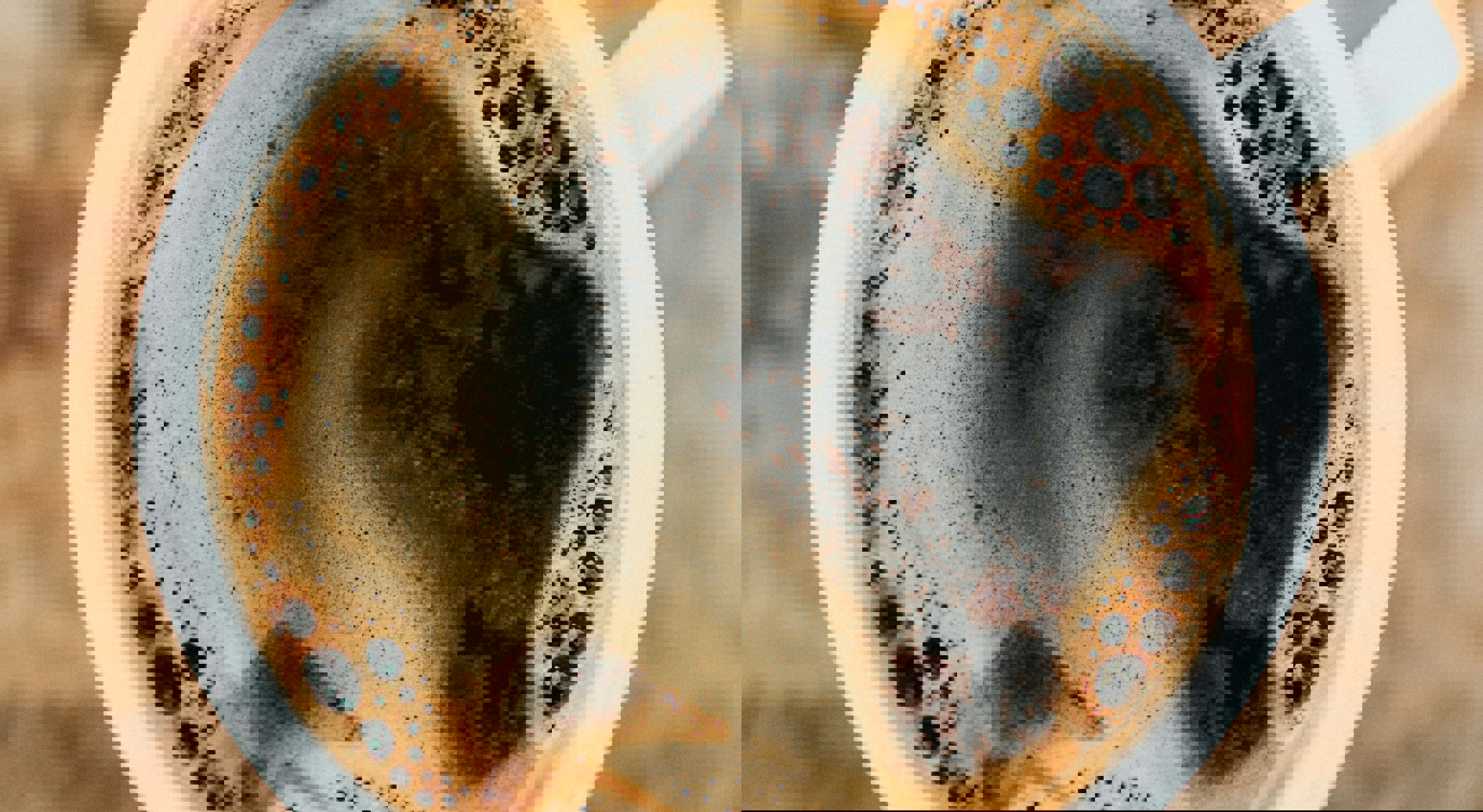 Oversikt over en rykende svart kaffe i en hvit kopp på et rustikt trebord