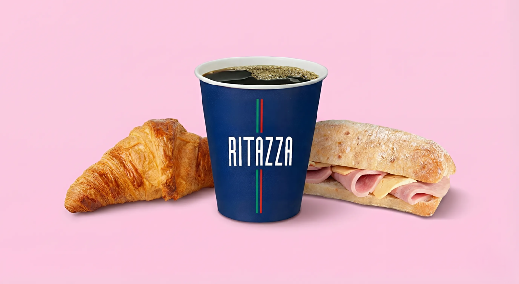 Kopp med svart kaffe, croissant og ciabatta med ost og skinke.