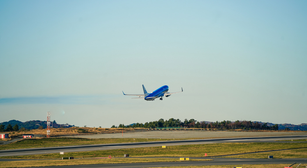 Fly tek av frå flyplass ein solfylt dag
