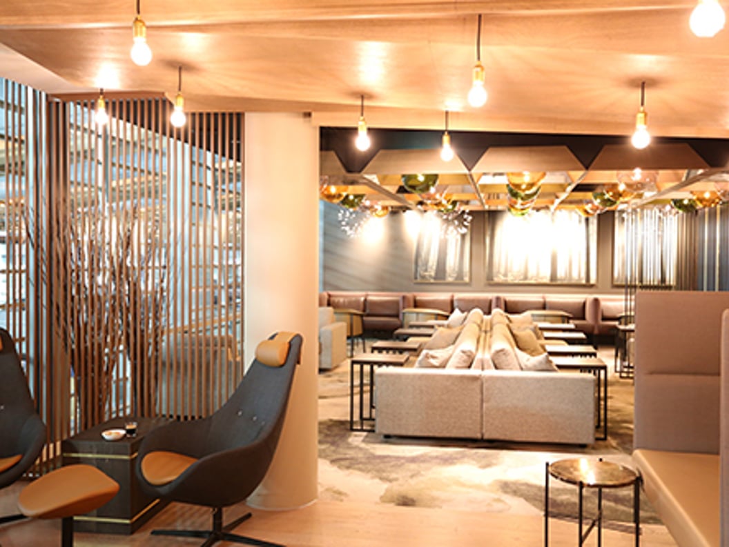 Modern lounge with stylish decor, comfortable seating, dim lighting, and decorative elements.