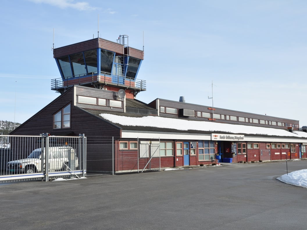 Control tower at Førde Airport in a snowy landscape, with a blue sky in the background.