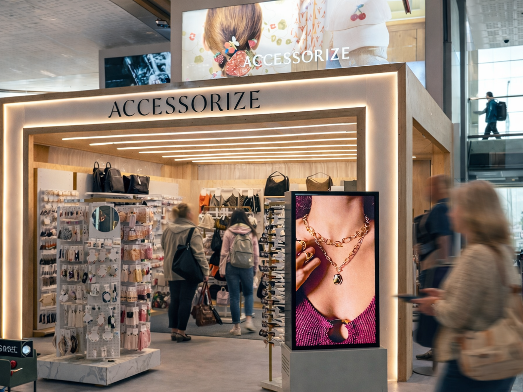 Fasadebilete av Accoessorize med produkt og ein stor skjerm i front.