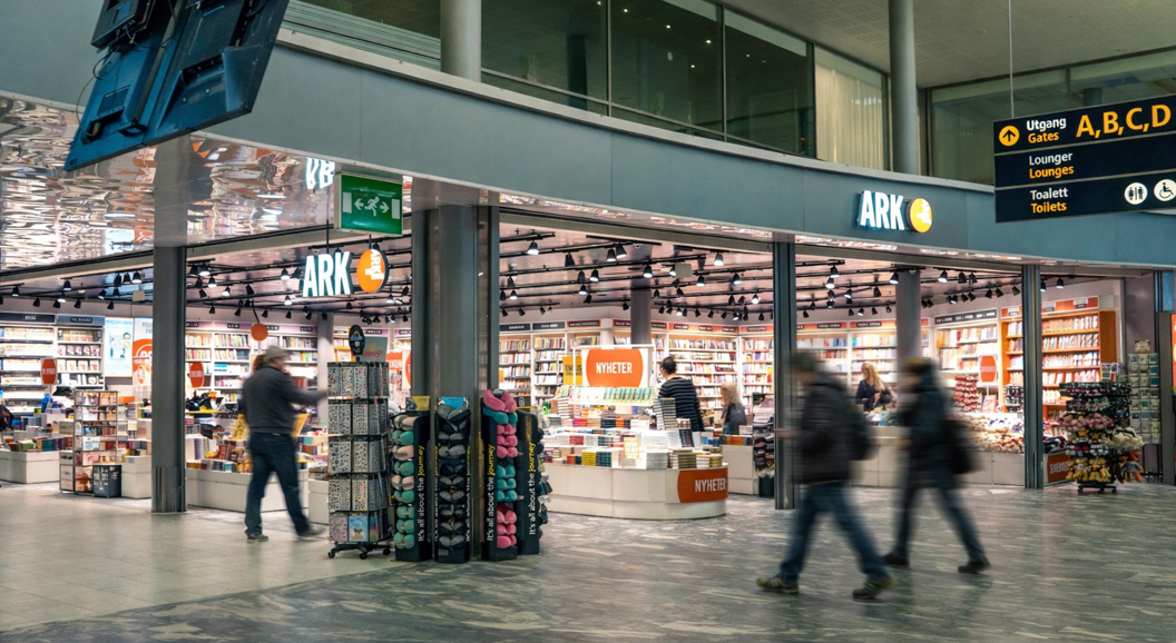 Kvinne ser på barnebøker i en bokhandel. Håndplukking av en bok fra hyllen i avdelingen for aldersgruppen 9-12 år.