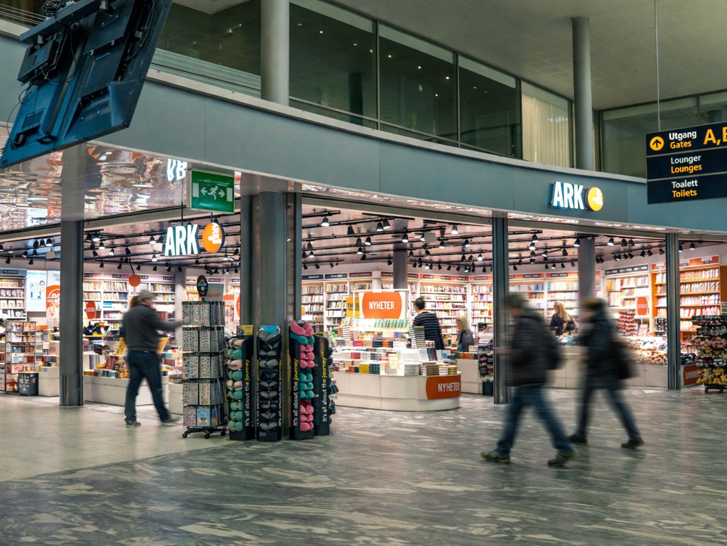 Kvinne ser på barnebøker i ein bokhandel. Handplukking av ei bok frå hylla i avdelinga for aldersgruppa 9-12 år.