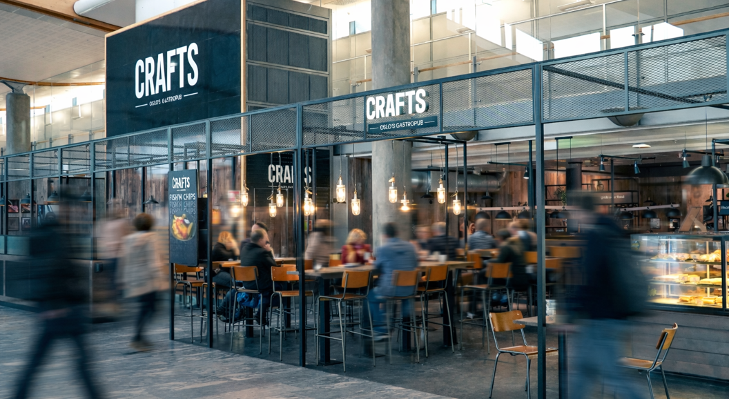 Gourmet burger and sweet potato fries with a glass of beer on a table at an airport lounge, airplane visible in the background