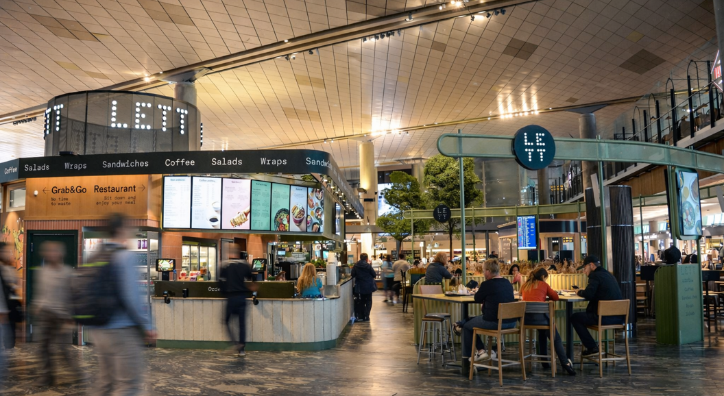 Assorted healthy salads with fresh vegetables, colorful smoothies, vibrant juices, and energy bites on a beige background