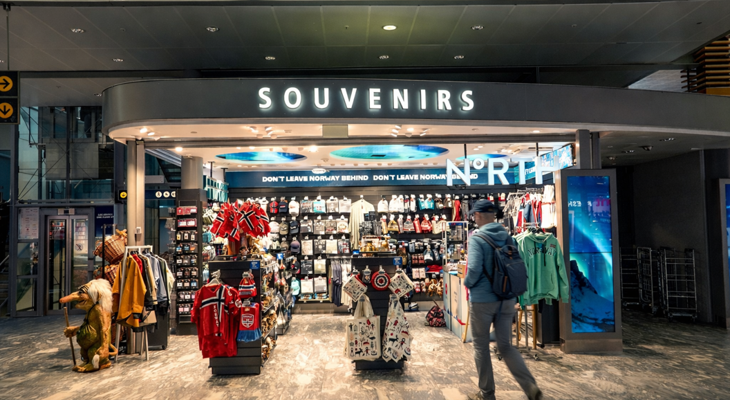 Suvenirbutikk i Norge med tradisjonelle skandinaviske klær, flagg og diverse gaver med fremtredende skilting for "Suvenirer" og "Nord