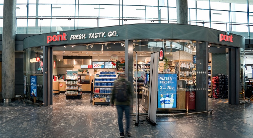 Storefront sign displaying the words "Point Fresh Tasty Go" in vibrant letters, promoting convenience and freshness
