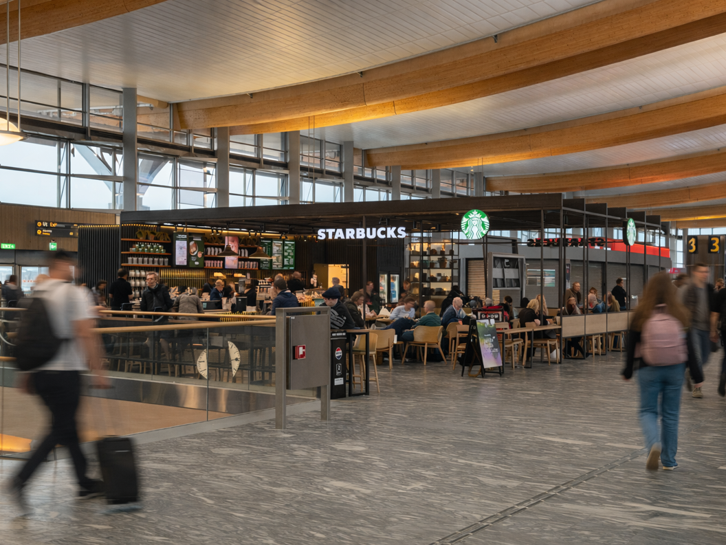 Person heller kaffe fra glass til kopp ved en kaffemaskin