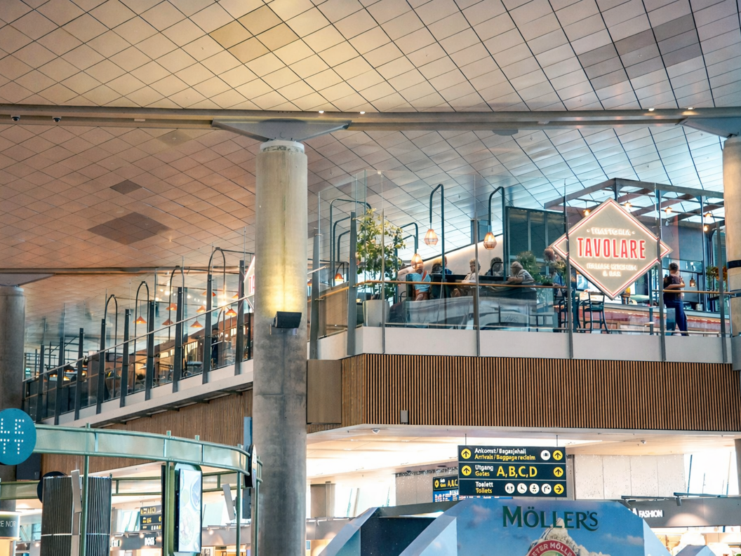 Tavolare Italian Kitchen & Bar sign within a modern shopping complex, featuring glass railings and decorative lighting