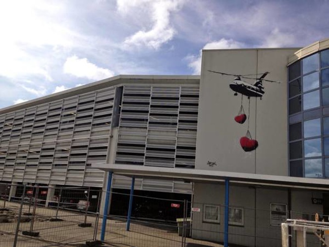 Artwork at Stavanger Airport, painting on the outside of the terminal building. Two hearts in red are hanging from a plane
