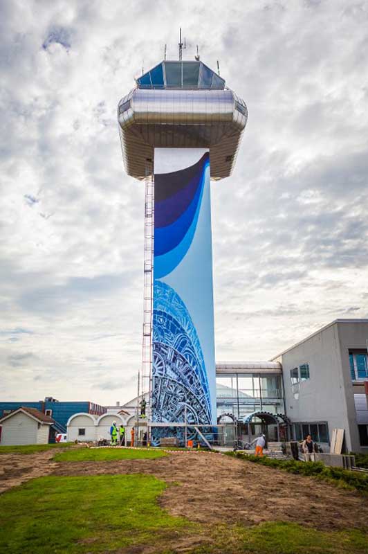 Kunstverk på Stavanger flyplass, kontrolltårnet er malt i nydelige blå farger og mønstre
