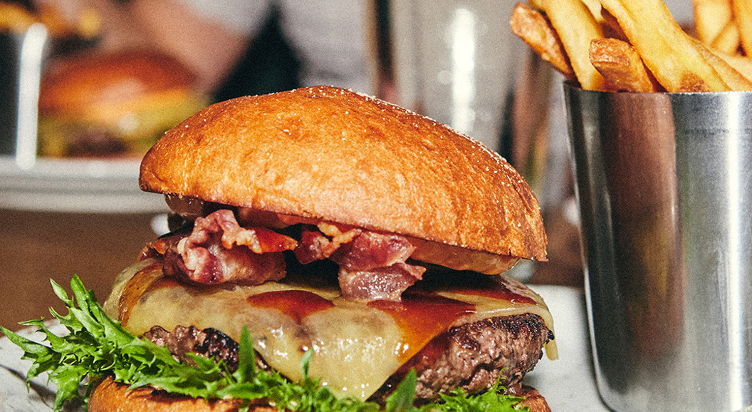 Boston Burger on a white plate with fries beside