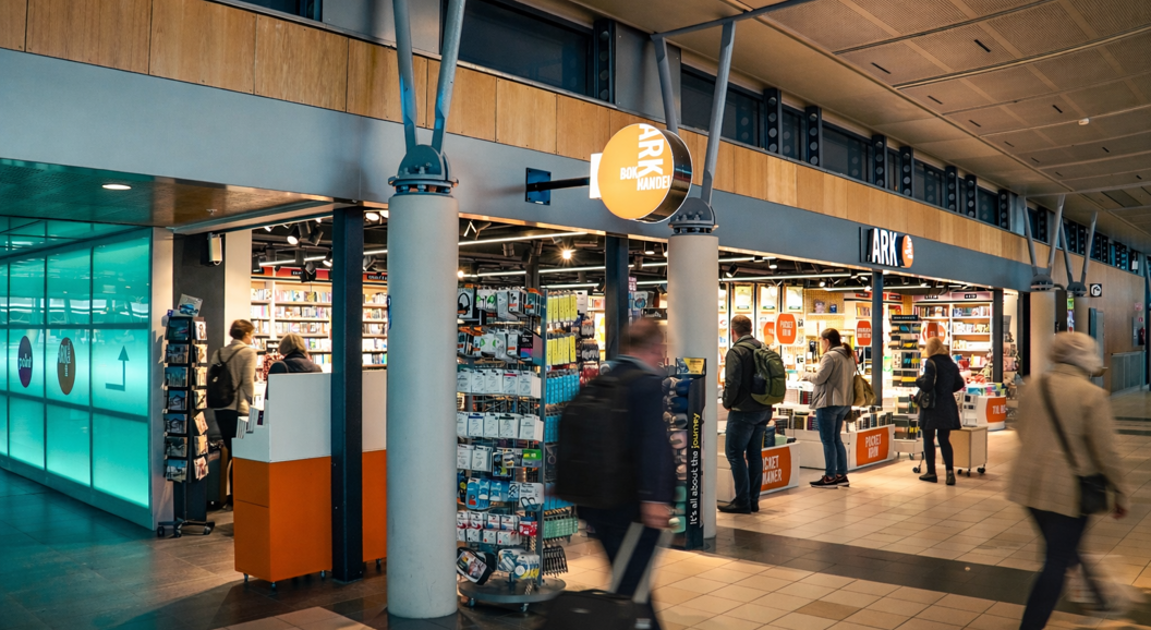 Kvinne blar gjennom fargerike barnebøker på en hylle i en bokhandel