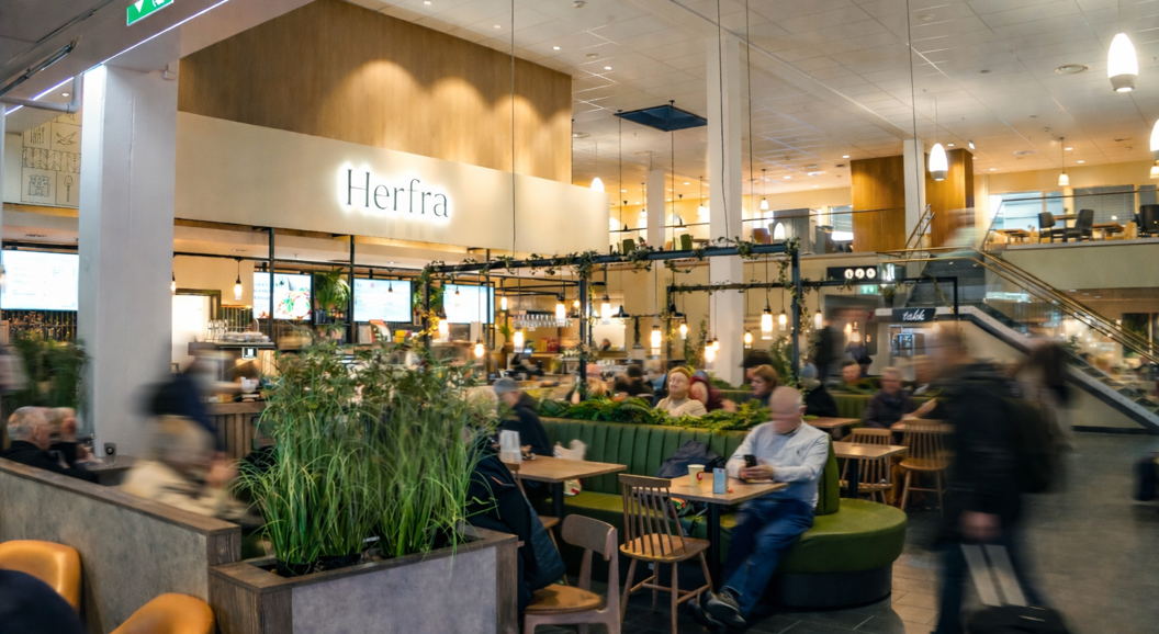 Tre gourmetsmørbrød med prosciutto, ost, tomat og ruccola på et trefat, stylet med en linduk