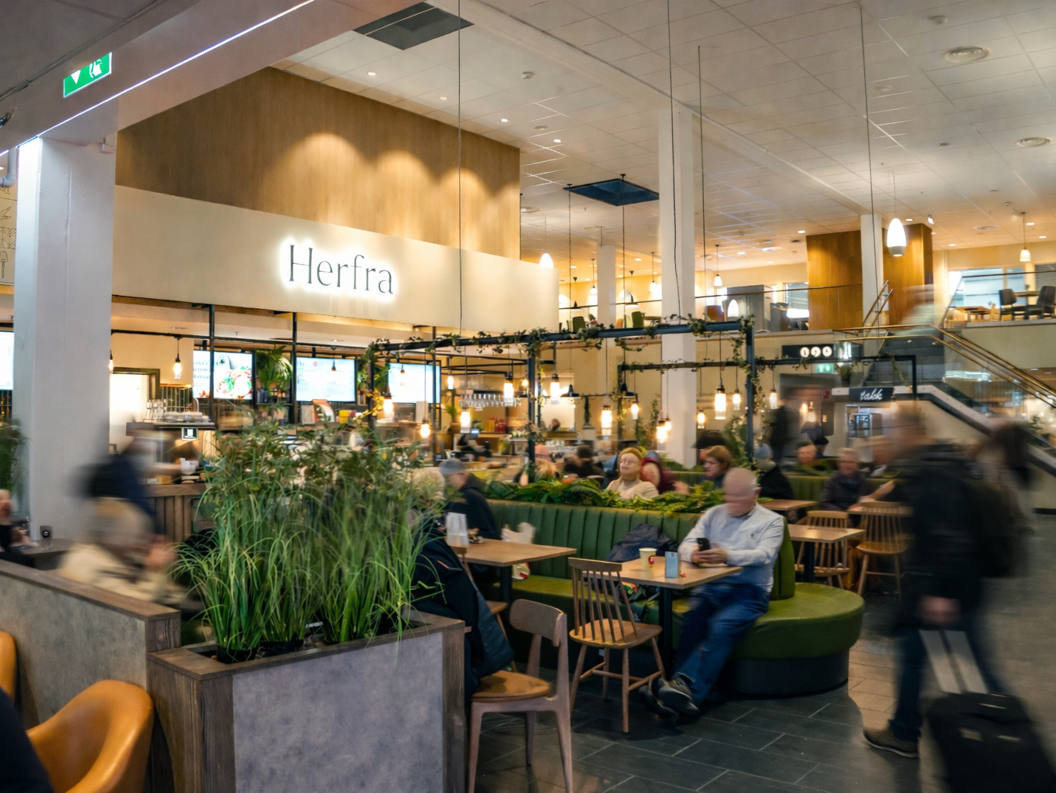 Tre gourmetsmørbrød med prosciutto, ost, tomat og ruccola på et trefat, stylet med en linduk