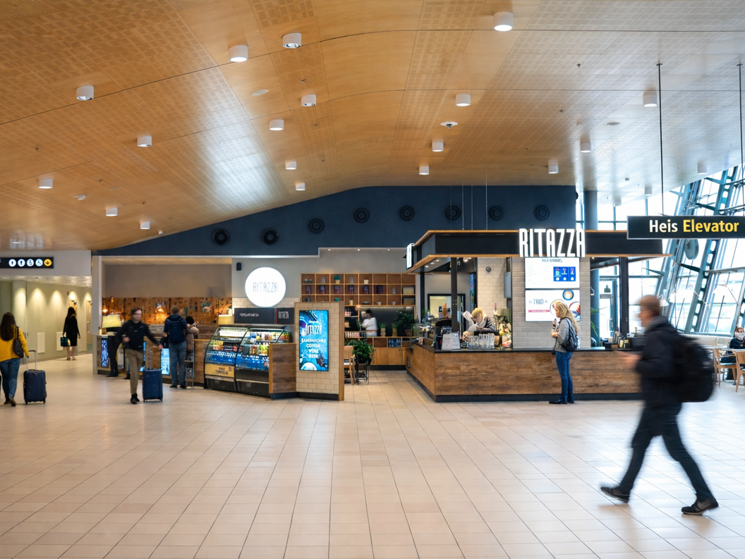 Iskaffe i glasskrus med isbiter på trefat, omgitt av kaffebønner og treskje